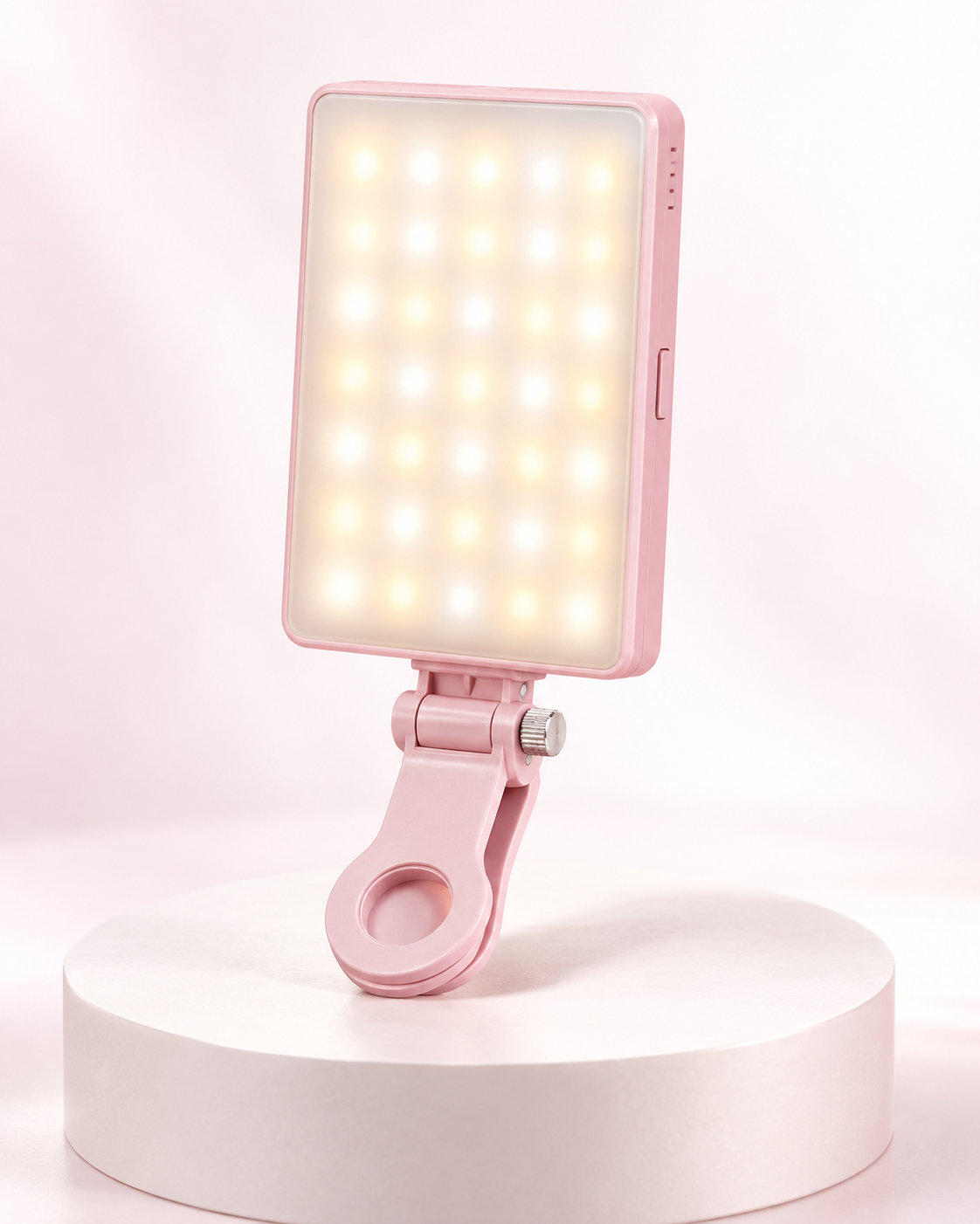 Pink rechargeable clip fill light standing on a base with glowing LED panel