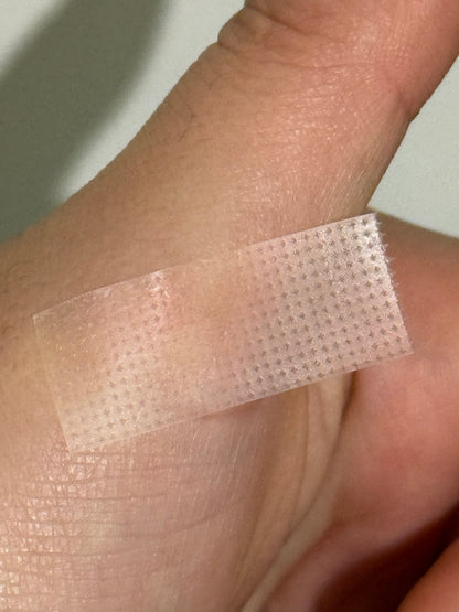 Translucent pink mesh tape strip for lash lifting, adhered on skin