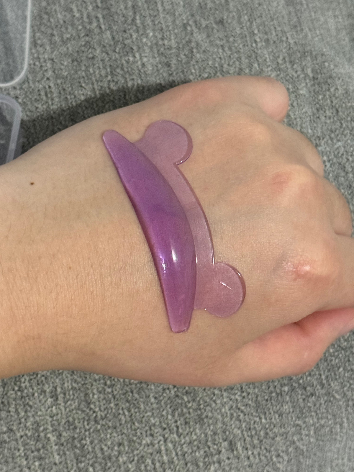 Miu Curl purple silicone perm pad on wrist, glossy gel finish