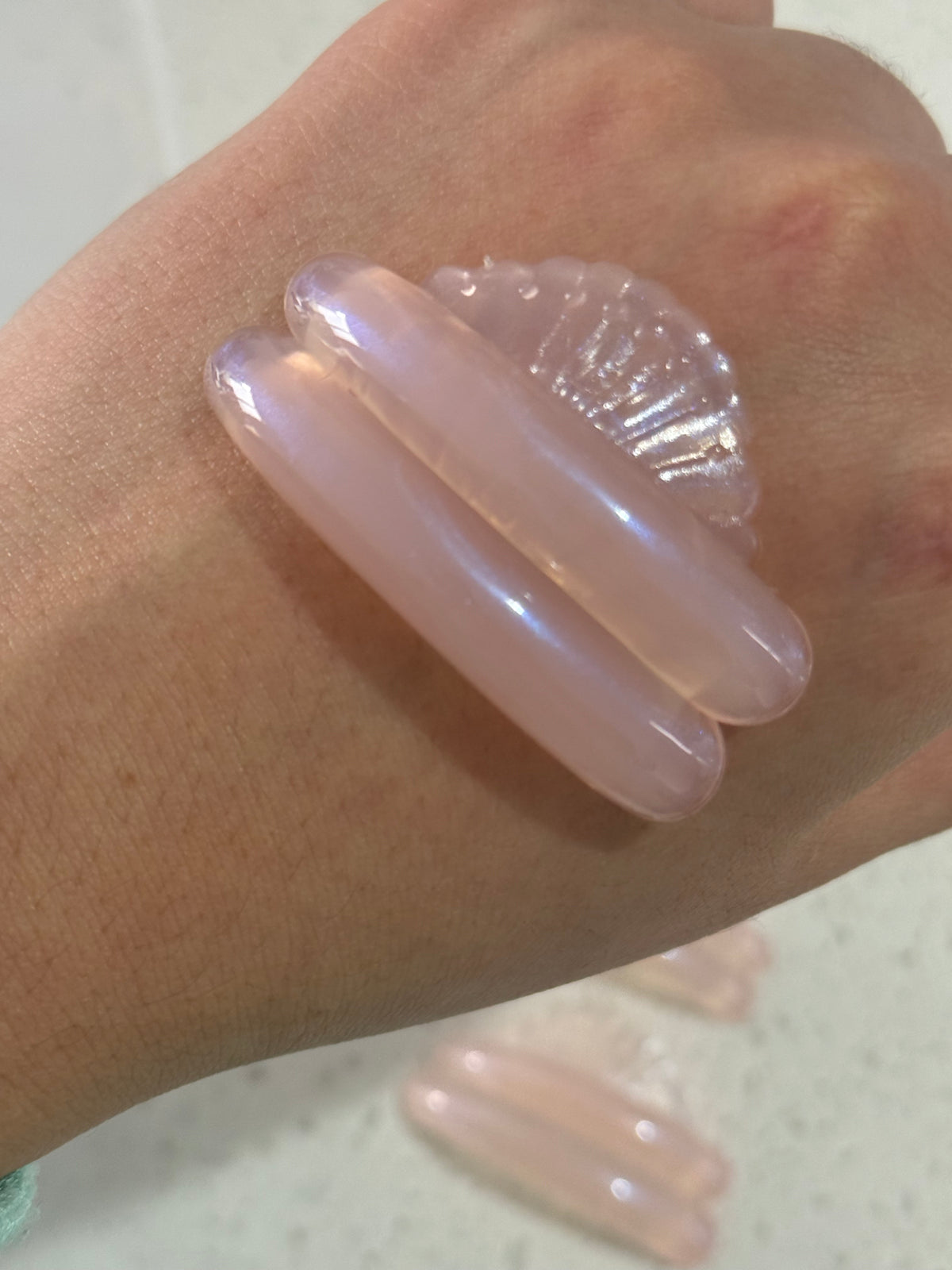 AÉRA Sora Curl silicone pad shown on skin, glossy curved texture