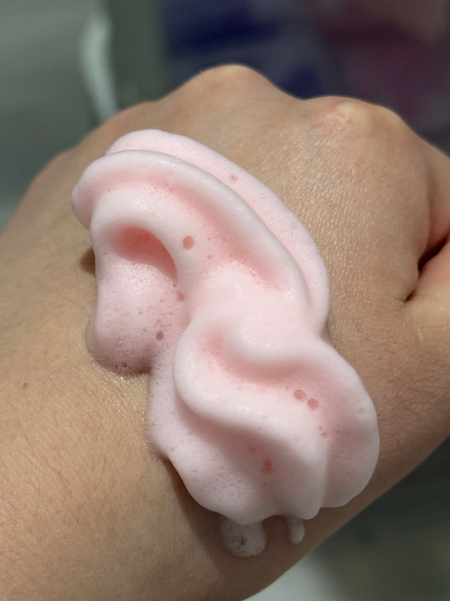 Whipped lash shampoo foam on skin, thick pink creamy lather