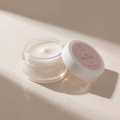 Opened balm jar with creamy white product beside closed white-lid jar