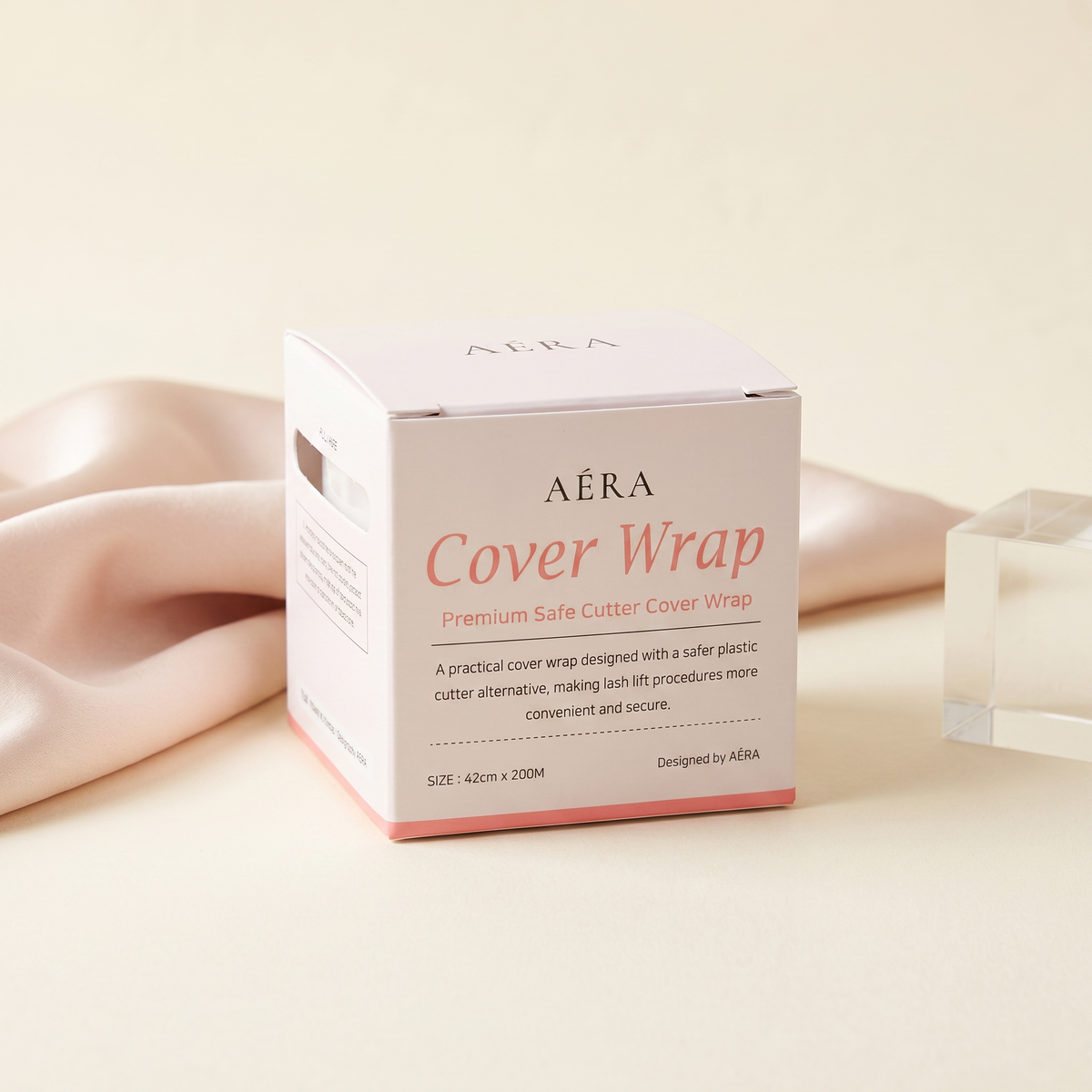 Cover wrap box side view, white with pink bottom; beige fabric edge visible